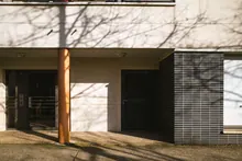 Fachada de un edificio de viviendas con sombras de árboles