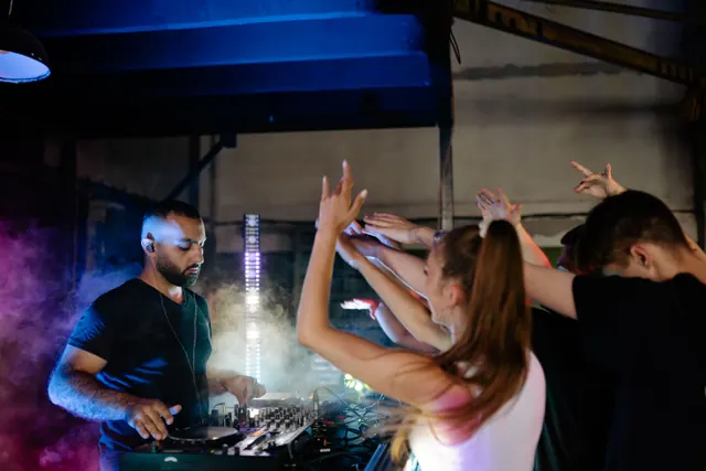 Un DJ pincha ante el público en una discoteca de música electrónica