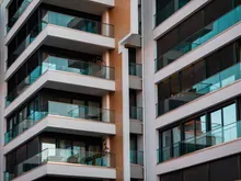 Fachada de un edificio de viviendas con balcones y ático acristalado