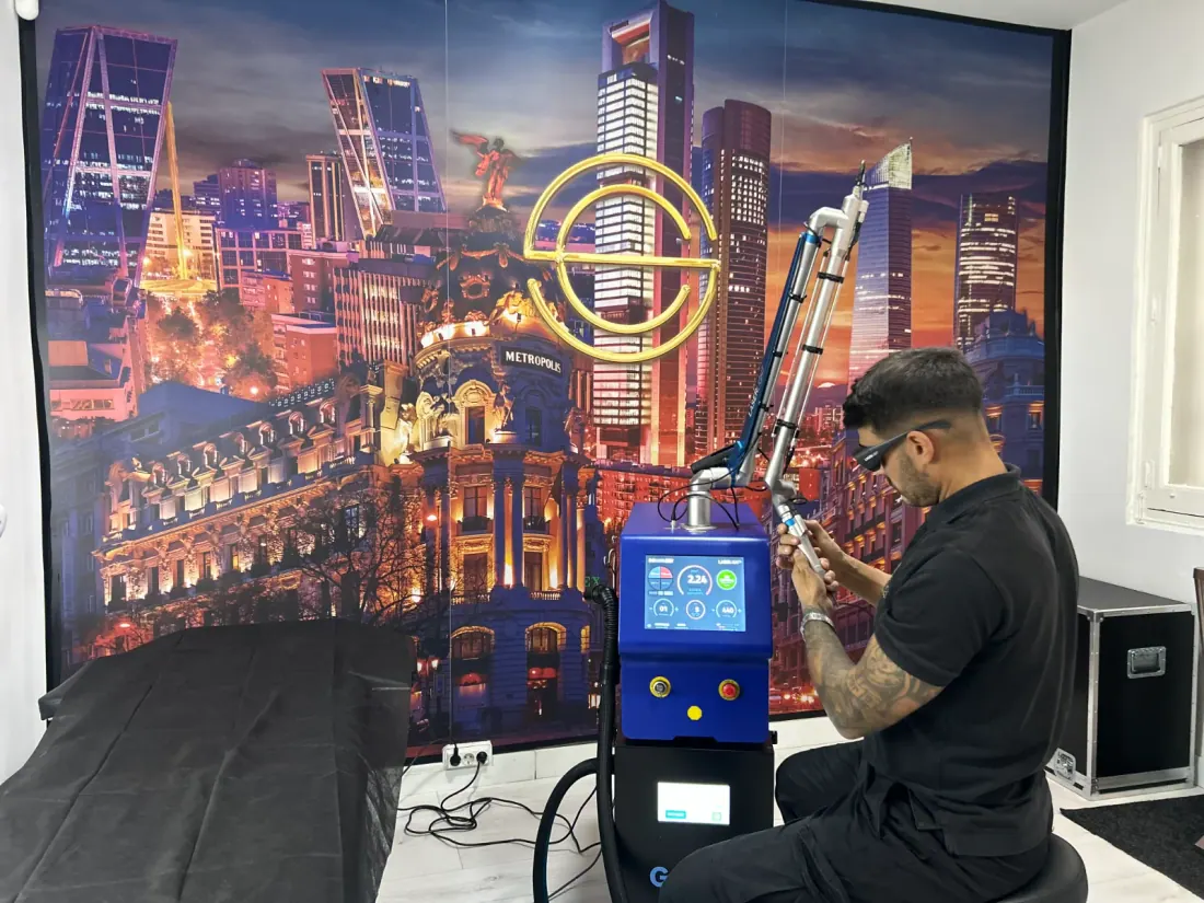 Un técnico manipula un equipo de láser en una clínica estética con mural de Madrid