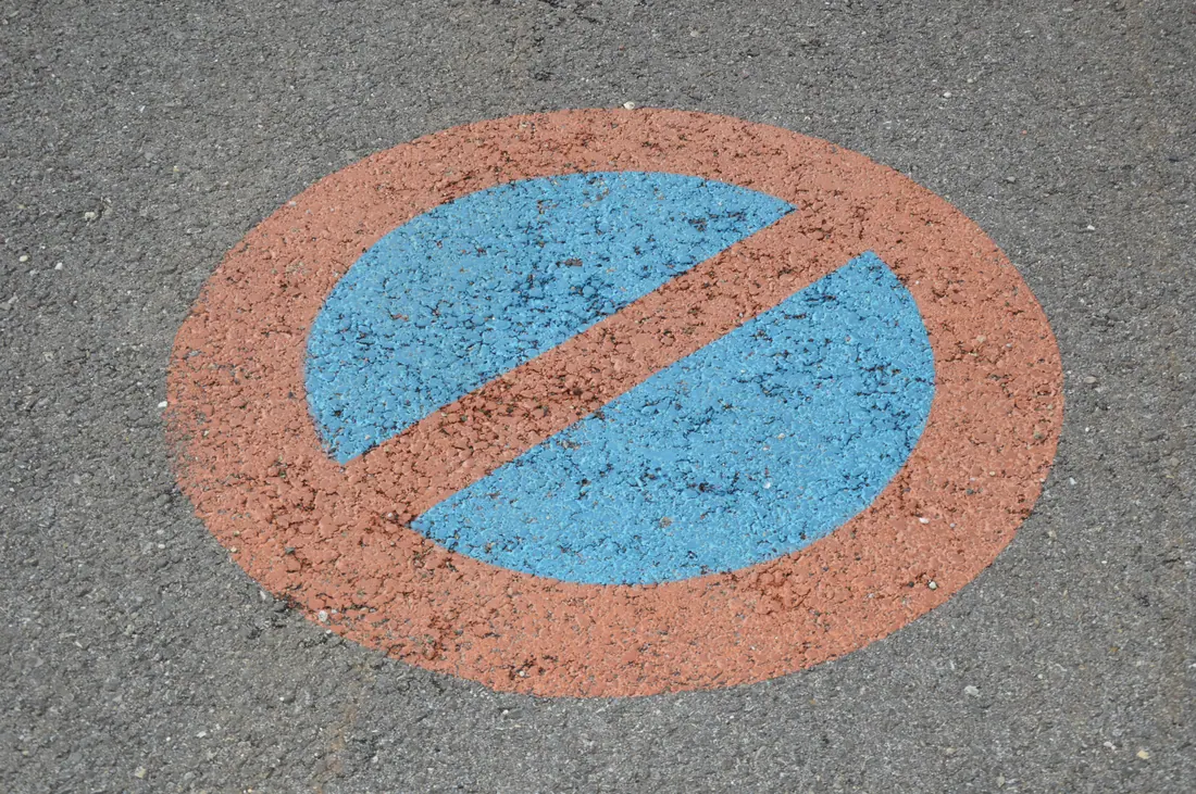 Señal de prohibido aparcar pintada en el asfalto