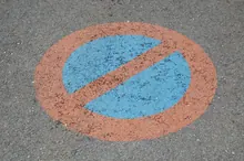 Señal de prohibido aparcar pintada en el asfalto