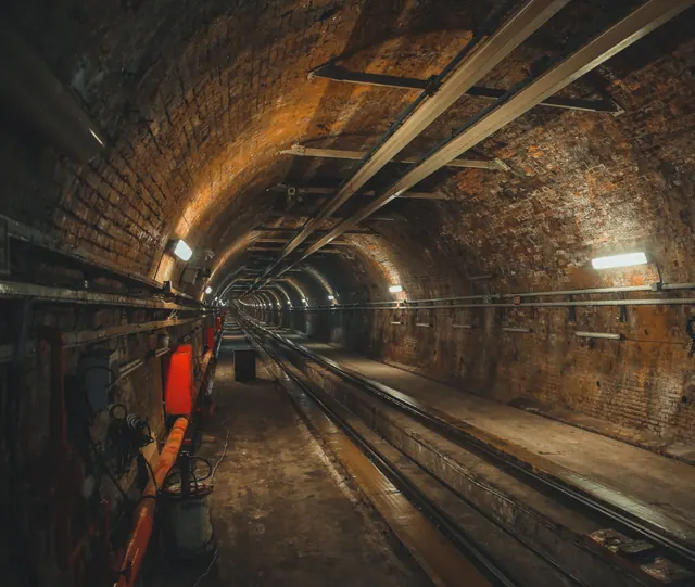 Túnel de ferrocarril de ladrillo con vías en su interior