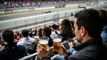 Aficionados con bebidas en las gradas de un circuito de Fórmula 1 durante una carrera
