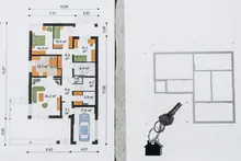 Planos arquitectónicos de una vivienda junto a unas llaves