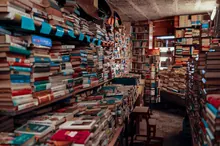 Interior de una librería repleta de pilas de libros