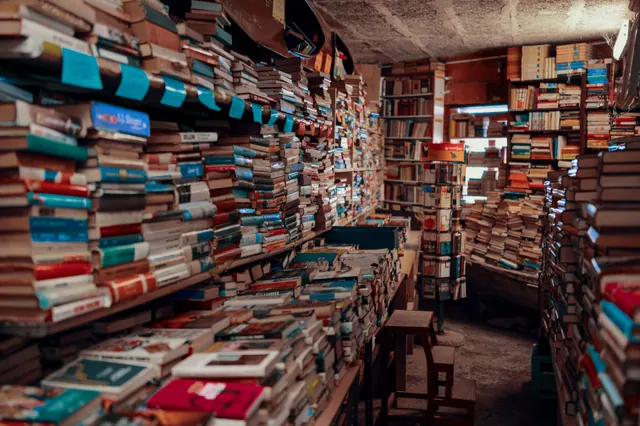 Interior de una librería repleta de pilas de libros