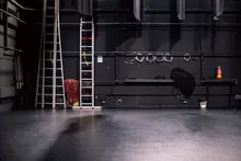 Escaleras y equipos apoyados entre bastidores de un teatro