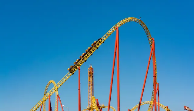 Montaña rusa con vagones ascendiendo por una pendiente pronunciada