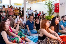 Público disfrutando de un concierto al aire libre, con las manos alzadas frente a un escenario iluminado