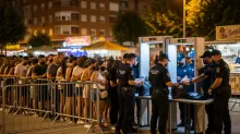 Agentes de policía controlan el acceso a un evento nocturno ante una cola de personas