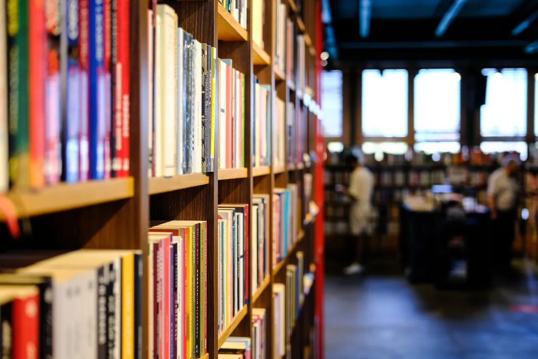 Estanterías de libros en una librería con personas al fondo