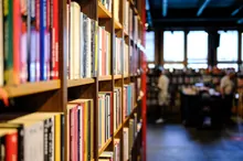 Estanterías de libros en una librería con personas al fondo