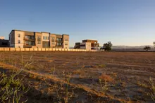 Edificios residenciales junto a un terreno baldío al atardecer