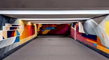Túnel peatonal decorado con un mural geométrico de colores