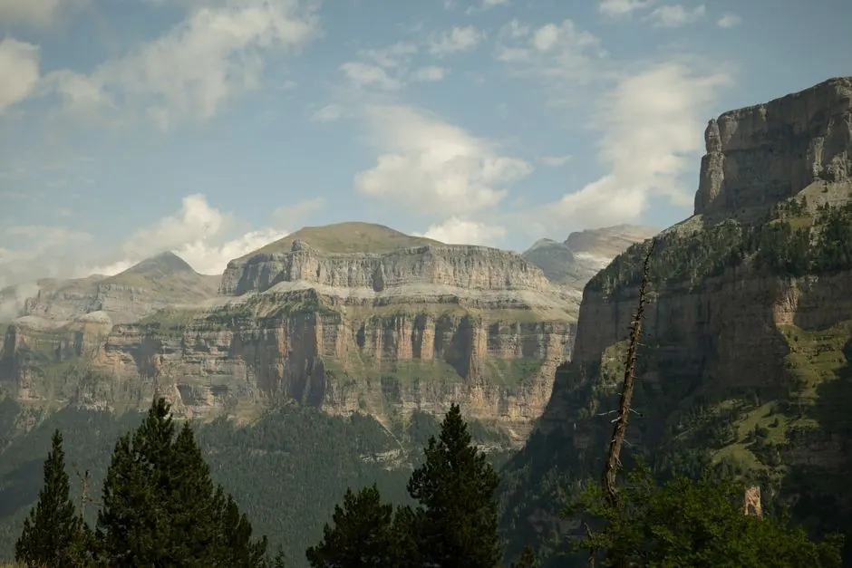 Sendero de montaña atravesando un cañón pirenaico con paredes rocosas verticales