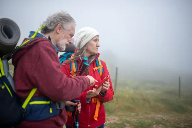 Senderista utilizando aplicación GPS en el móvil durante una ruta de montaña