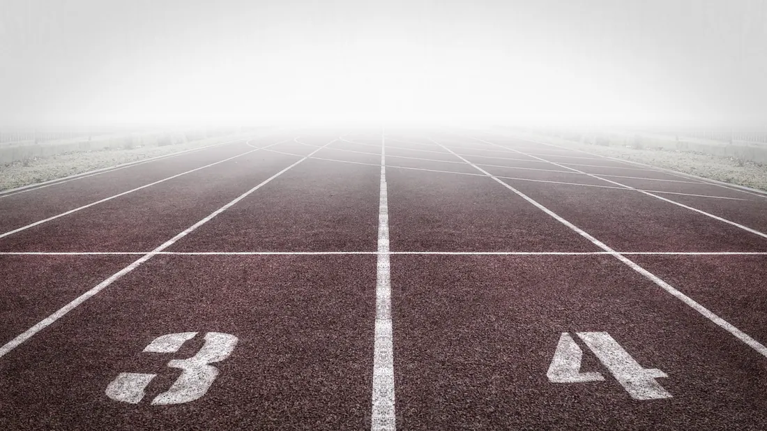 Pista de atletismo con carriles numerados entre niebla
