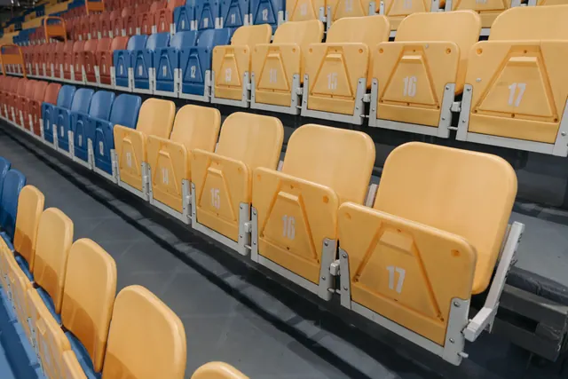 Filas de asientos vacíos numerados en una grada de estadio