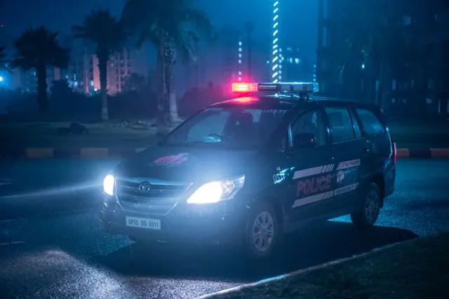Vehículo policial con luces de emergencia en entorno urbano nocturno