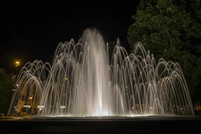 Espectáculo nocturno de fuente con luz y sonido en un parque