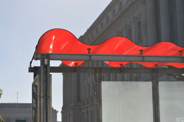 Marquesina ondulada roja frente a un edificio monumental