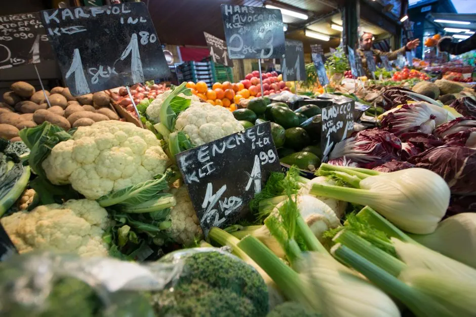 Puesto de verduras frescas y productos locales en un mercado tradicional español