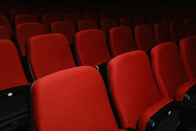 Filas de butacas rojas vacías en una sala de cine o teatro
