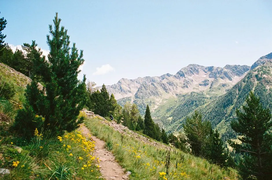 Senderista recorriendo una ruta circular de montaña en España con paisaje de cumbres y valles