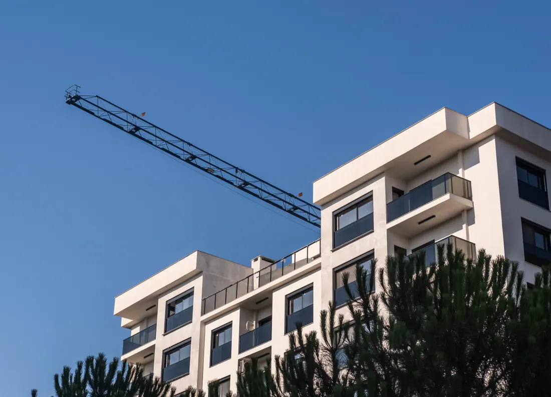 Edificio de viviendas moderno con una grúa de construcción al fondo