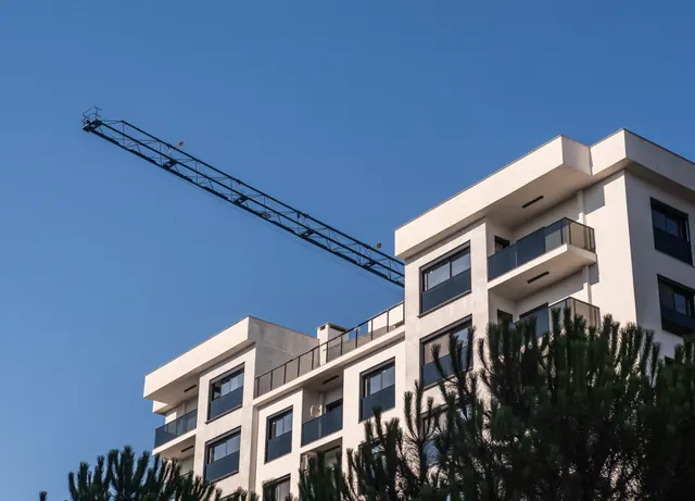 Edificio de viviendas moderno con una grúa de construcción al fondo