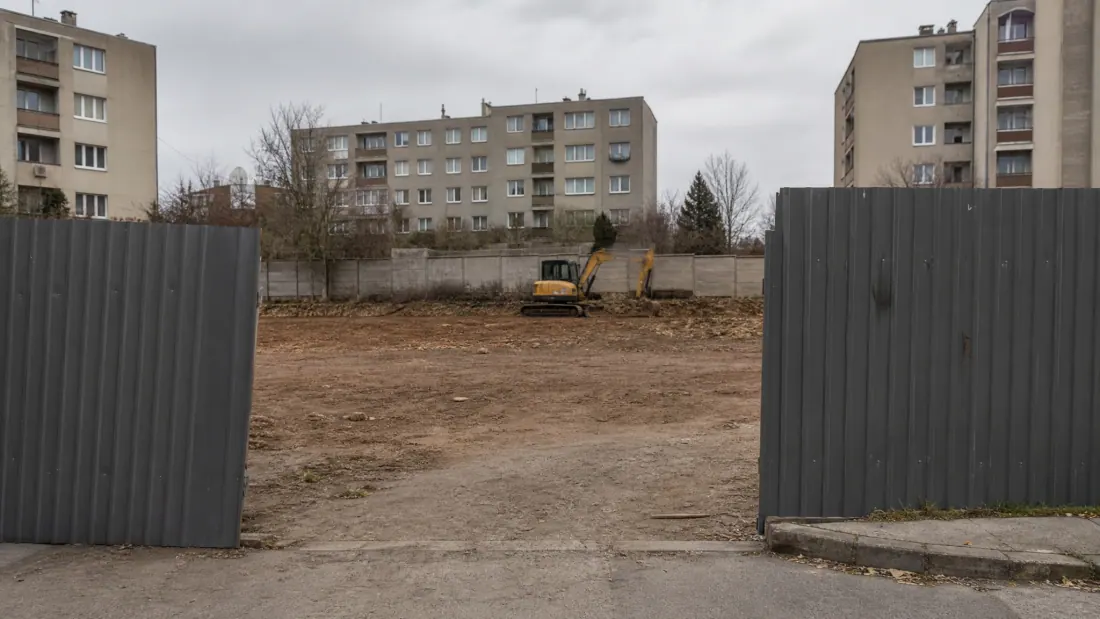 Maquinaria de construcción en un terreno vacío entre bloques de viviendas