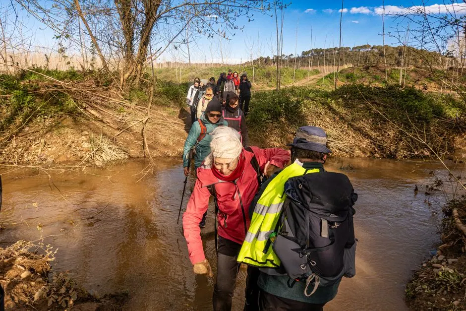 Familia con niños caminando por sendero natural de montaña en España