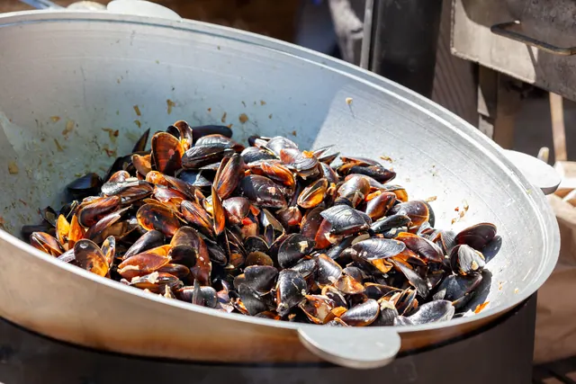 Mejillones cocinados en un gran recipiente metálico