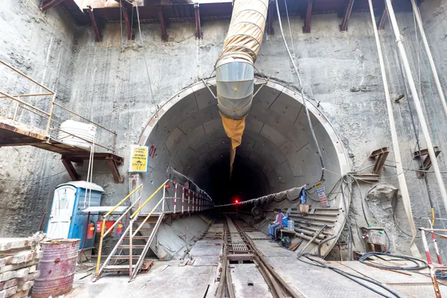 Túnel de metro en construcción con revestimiento de hormigón e iluminación provisional
