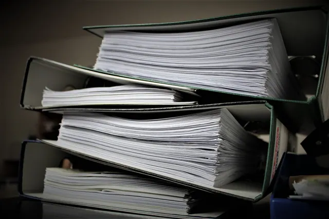 Carpetas archivadoras apiladas llenas de documentos
