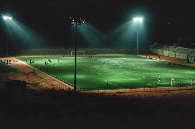 Un campo de fútbol iluminado por focos durante la noche