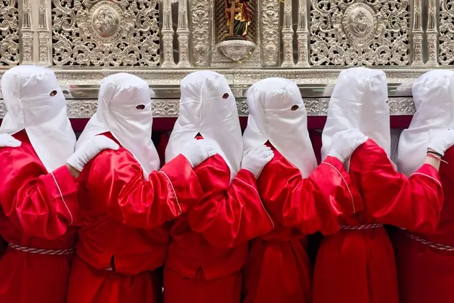 Desfile de moros y cristianos con trajes tradicionales bordados y música de fanfarria en España