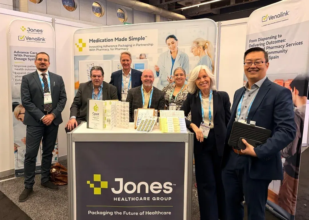 Un grupo de profesionales posa en el estand de Jones Healthcare Group en una feria