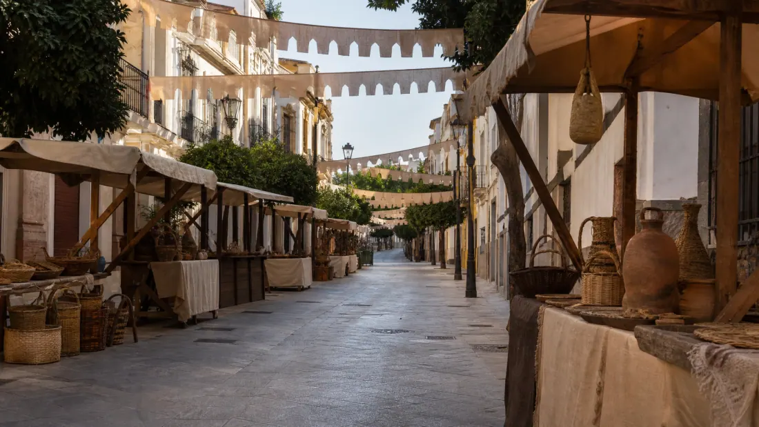 Calle medieval con puestos de mercado y tiendas de artesanía en una ciudad histórica