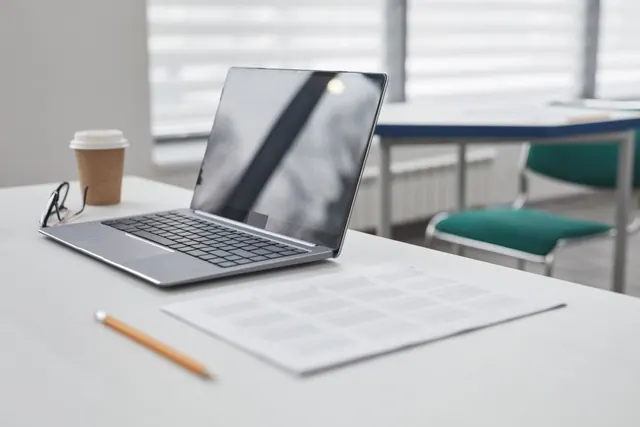 Un ordenador portátil y un vaso de café sobre una mesa