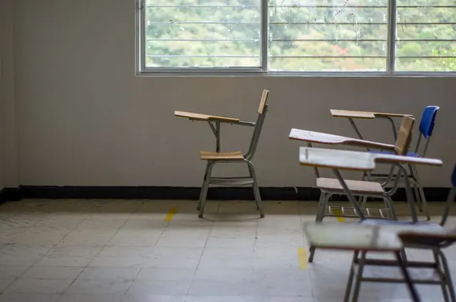 Aula escolar vacía con pupitres y pizarra en un colegio de la Comunidad de Madrid