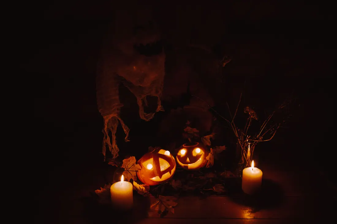 Calabazas de Halloween iluminadas con velas y una figura fantasma