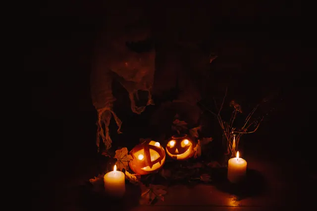 Calabazas de Halloween iluminadas con velas y una figura fantasma