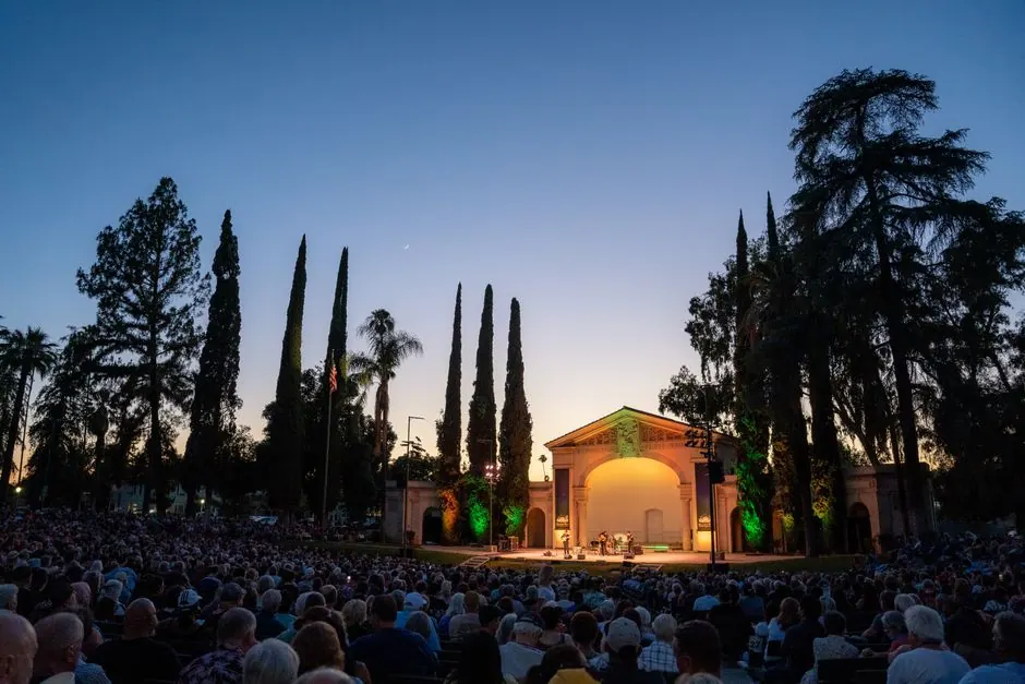 Representación teatral al aire libre en un parque durante el atardecer