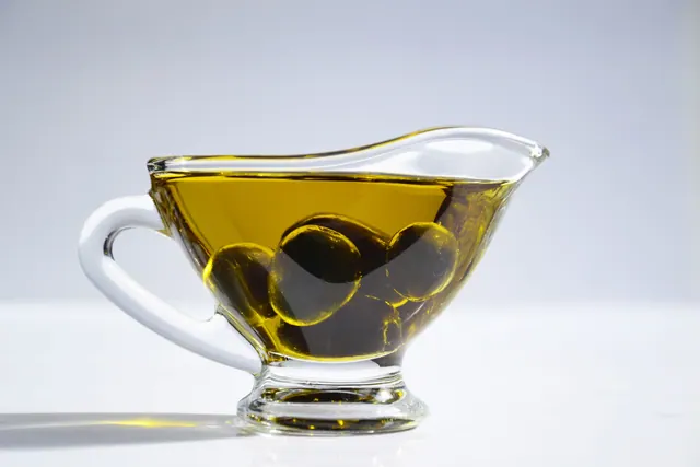 Aceite de oliva con aceitunas en una salsera de cristal