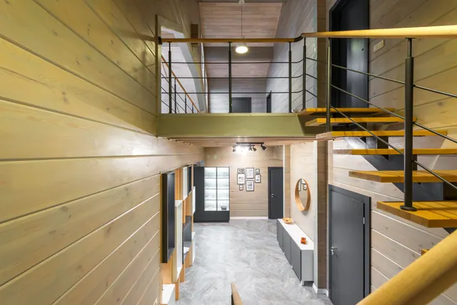 Interior de una vivienda de madera con escalera y entreplanta