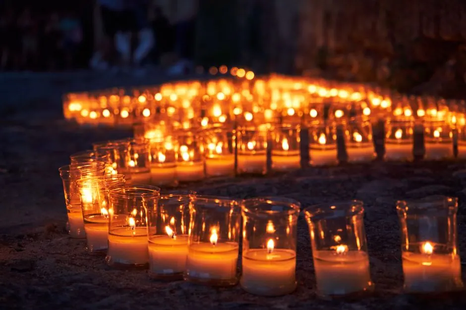 Celebración festiva nocturna en pueblo español con iluminación tradicional y vecinos reunidos