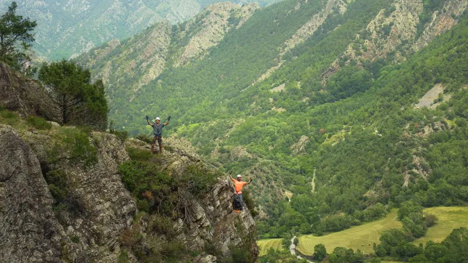 Vía ferrata equipada en pared rocosa de montaña con cable de acero y grapas metálicas