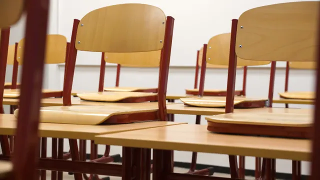 Sillas colocadas sobre las mesas en un aula vacía